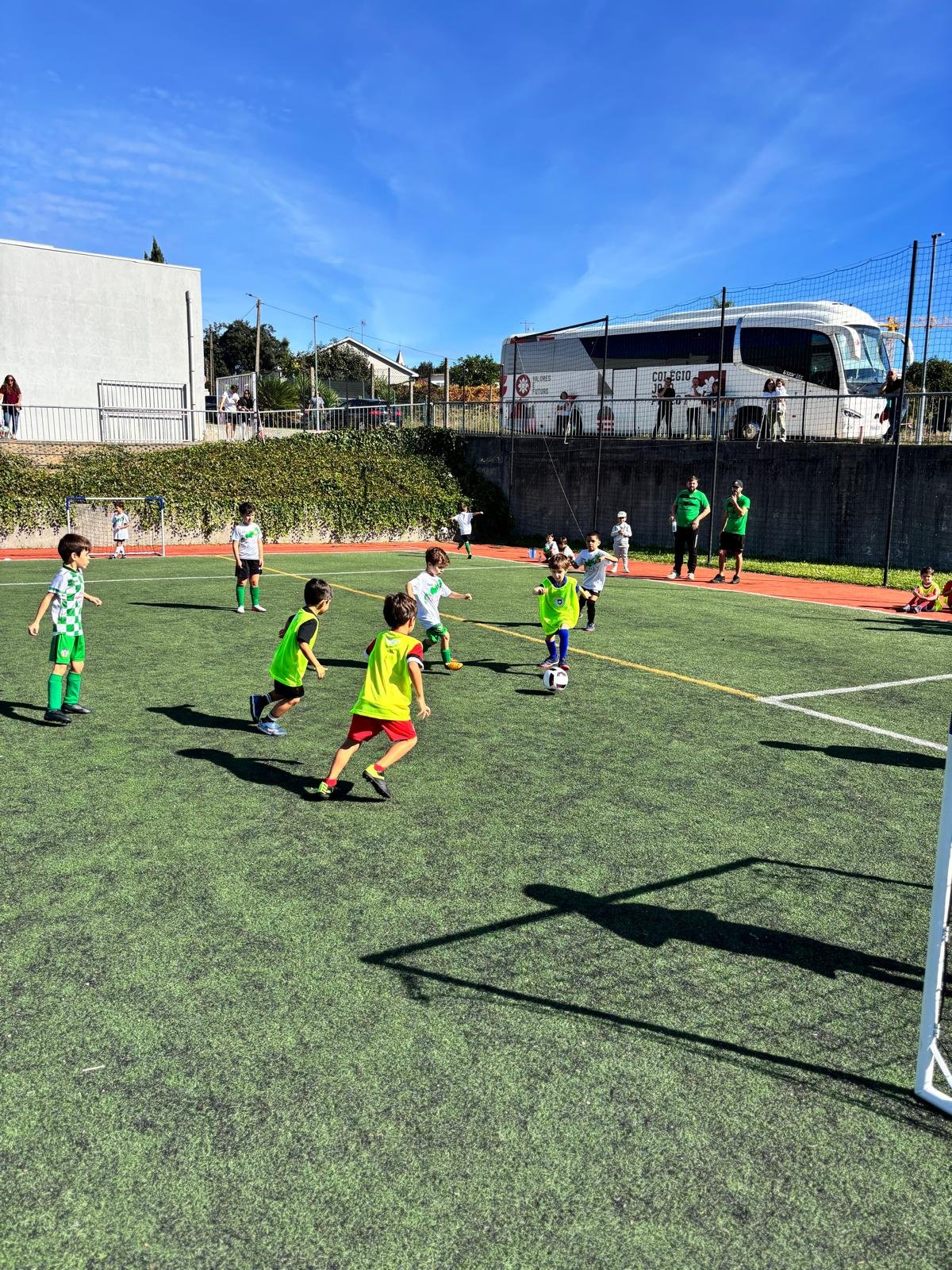 Crianças do Clube Desportivo do Colégio João Paulo II disputam a bola num jogo de futebol, em campo de relva sintética