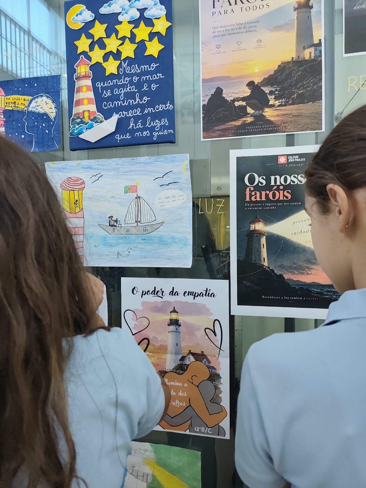 Cartazes e trabalhos dos alunos sobre faróis, expostos num vidro do colégio