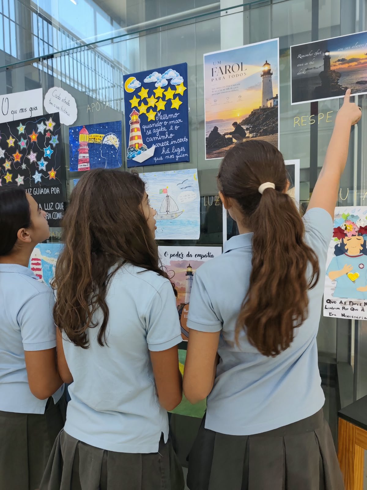 Uma aluna a apontar para um dos cartazes expostos